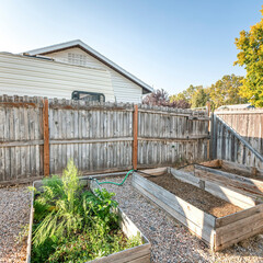 Square frame Backyard with raised bed garden and wooden fence and gate