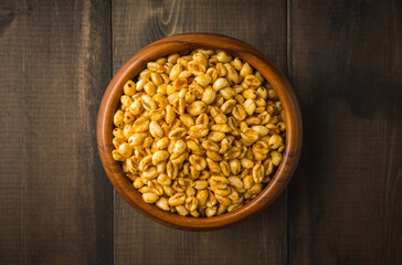 Wheat flakes cereal breakfast in wooden bowl on the rustic background. Selective focus.