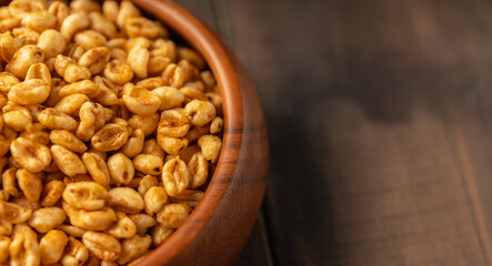 Wheat flakes cereal breakfast in wooden bowl on the rustic background. Selective focus.