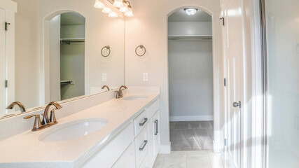 Pano Interior of a white bathroom with shower with glass wall, sink and empty closet
