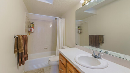 Pano Interior of a bathroom with wall lightning, vanity sink and bathtub