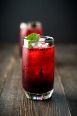 Blackberry cocktail with crushed ice on the rustic wooden background. Selective focus. Shallow depth of field.
