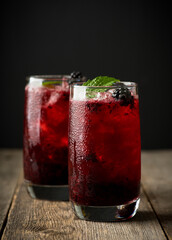 Blackberry cocktail with crushed ice on the rustic wooden background. Selective focus. Shallow depth of field.
