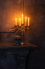 Scary laughing pumpkin and old skull on ancient gothic fireplace. Halloween, witchcraft and magic.