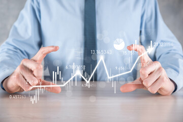 Businessman in hand hold banking business finance graph and invest in stock market investment point,economic growth and investor concept.analysis virtual stock market chart,analyze by use technology