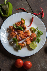 Chicken kebabs or doners grilled with saute vegetables in a white plate. Top view.	