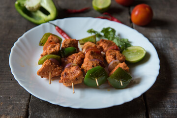 Chicken kebabs or doners grilled with saute vegetables in a white plate. Close up.