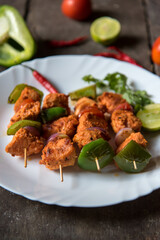 Close up of grilled chicken wings with vegetables in skewers. Selective focus.