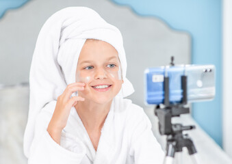 Young happy girl filming her beauty blog about  face skin care. Kids blogger concept