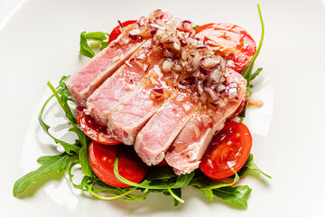 tuna fillet with salad on white plate