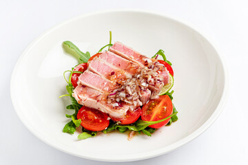 tuna fillet with salad on white plate