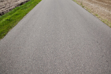 Narrow paved country road and farmland.