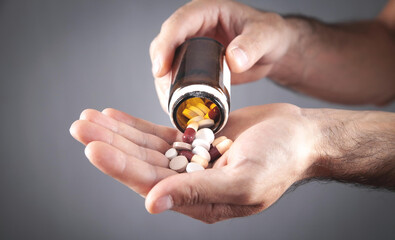 Male hand holding bottle of medical pills.