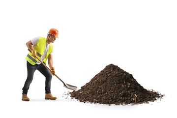 Construction worker with a vest and hardhat digging earth with a shovel