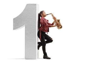 Full length profile shot of a female saxophonist playing and and leaning on a number one