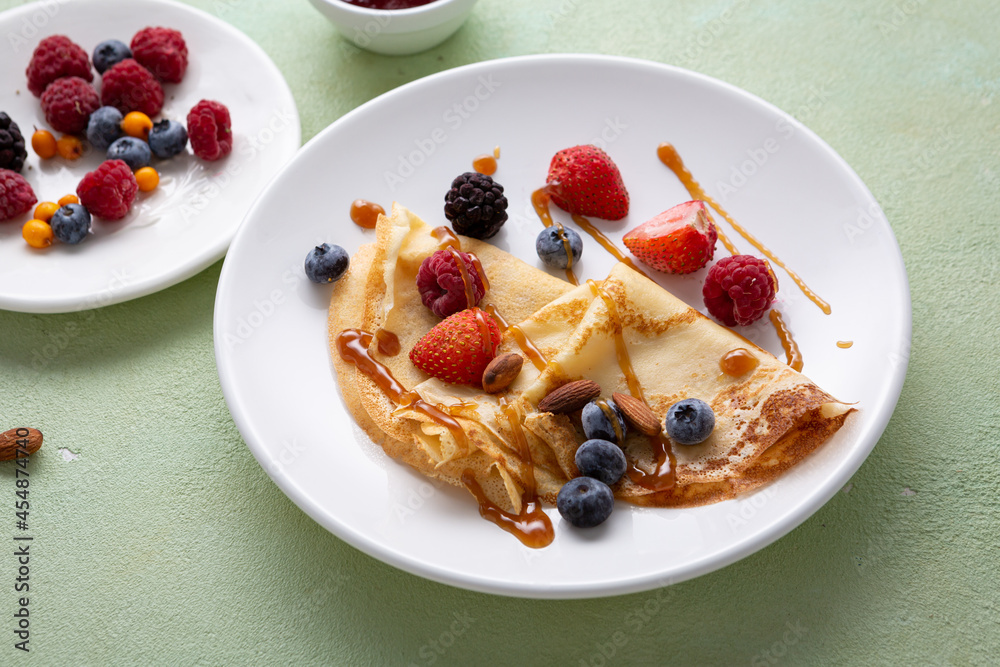 Wall mural crepes pancakes with berries on white plate food