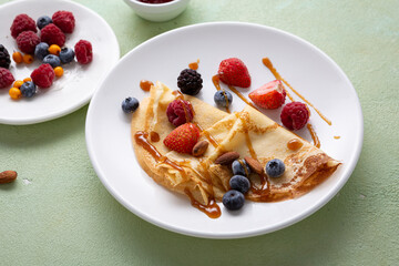 Crepes pancakes with berries on white plate food