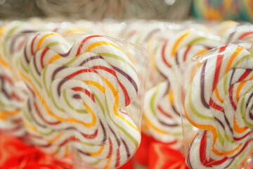 Shop window with coloured lollipops on stick. Sweet candies dessert for kids. Caramel snacks on sale.