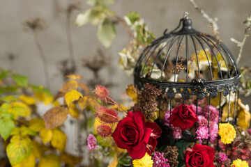 A close up of metal black cage with floral arrangement