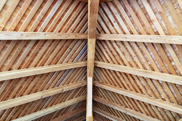 Construction of a wooden roof from the inside. Wooden background