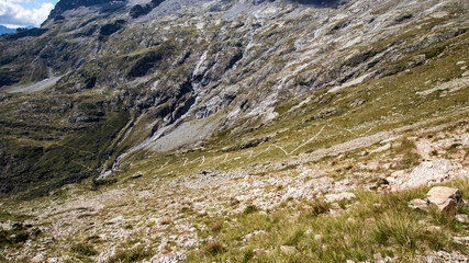 Sentier de haute montagne alpine serpentant, hiking trail winding in the high mountains