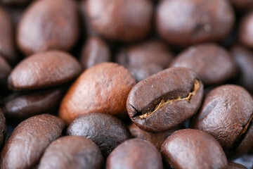 one roasted coffee bean background extrime macro close up on heap upset down grains, top view.