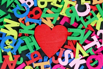 Colored letters of the alphabet surround the red heart shape in the center