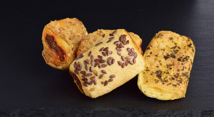 Assorted salty snacks of tuna, cheese and sobrassada on a slate board.