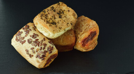 Assorted salty snacks of tuna, cheese and sobrassada on a slate board.