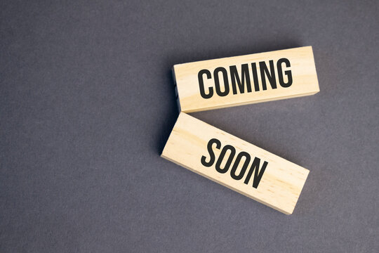 Coming Soon words on wooden blocks on yellow background. Business ethics concept.
