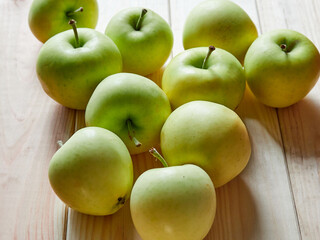Young organic apples lie on a wooden table