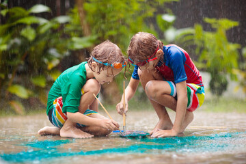 Obraz na płótnie Canvas Kids playing in the rain. Chalk drawing fun.