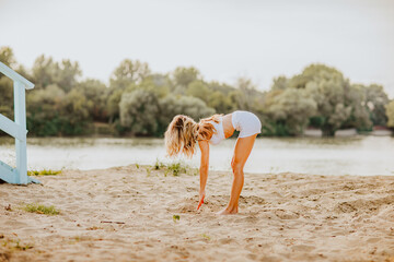 Fototapeta na wymiar Woman in white shorts and top practice yoga and fitness at the beach. 