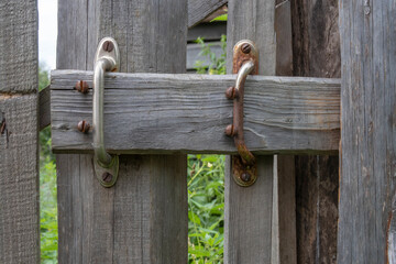 2 metal handes and a bolt are used to close old wooden door securely. Protection concept