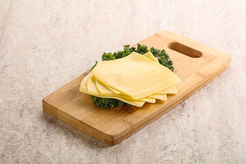 Sliced Gouda cheese over board