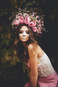Young woman with painted skull on her face for Mexico's Day of the Dead. portrait of Calavera Catrina in pink dress