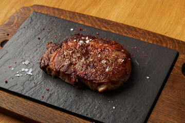 Fried pork chop on a bone lies on a black board