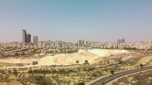 Landing behind a highway and bridge with new expensive districts in Beer-Sheba city with private buildings and towers at horizont