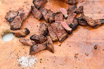 Sliced steak with salt and black pepper. Overhead view platter of grilled steak.