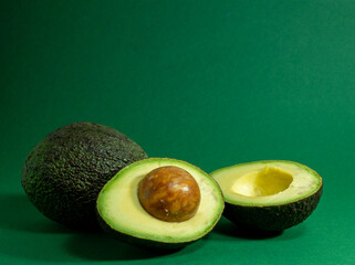 Fresh organic avocado on a green background.