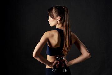sporty woman in black top with dumbbells in hands cropped view of workout exercise