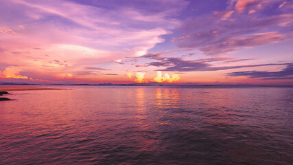 Naklejka premium Nature in twilight period which including of sunrise over the sea and the nice beach. Summer beach with blue water and purple sky at the sunset. 