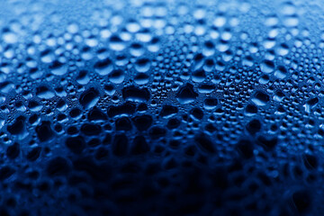 Drops on glass. Texture for designer background. Drops of water flow down the surface of the clear glass on a black background. Raindrops for overlaying on window. Concept of autumn weather.