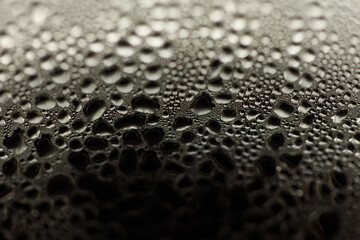 Drops on glass. Texture for designer background. Drops of water flow down the surface of the clear glass on a black background. Raindrops for overlaying on window. Concept of autumn weather.