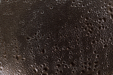 Drops on glass. Texture for designer background. Drops of water flow down the surface of the clear glass on a black background. Raindrops for overlaying on window. Concept of autumn weather.