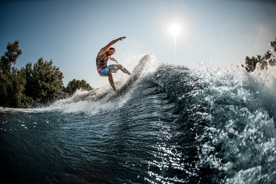 beautiful view of the great splashing wave and man balanced on it on foilboard