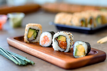 detail of salmon sushi served on wooden tray