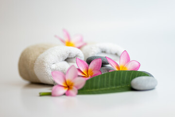 Roll towel with frangipani flower with leaf and spa stones