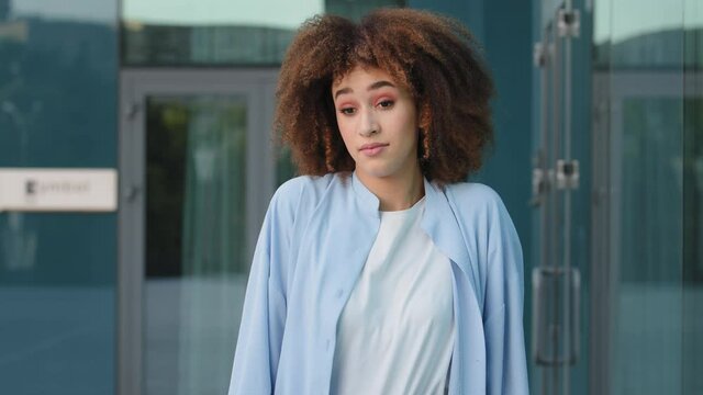 Pensive pondering african american woman ethnic mixed race girl with curly hair scratch head standing outdoors thinking make decision shrugs answering unidentified uncertainly definitely unknown
