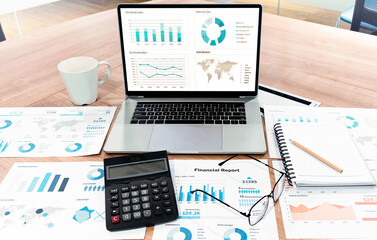 Top view mock up sales summary slide show presentation on display laptop with calculator ,glasses and paperwork on table in meeting room